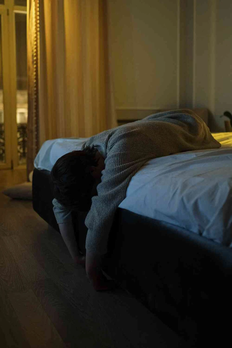 Peson liegt ersch&ouml;pft auf dem bett